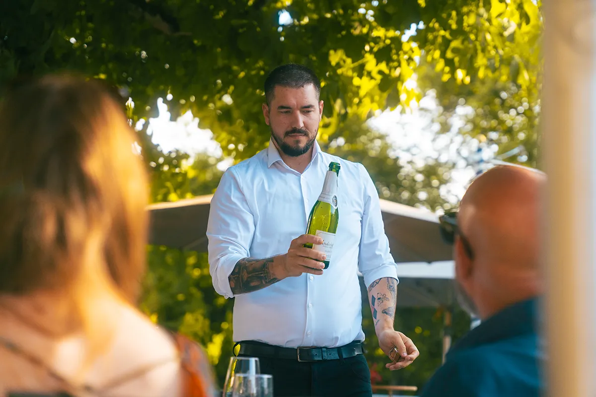 Kellner präsentiert Wein im Andechser Hof