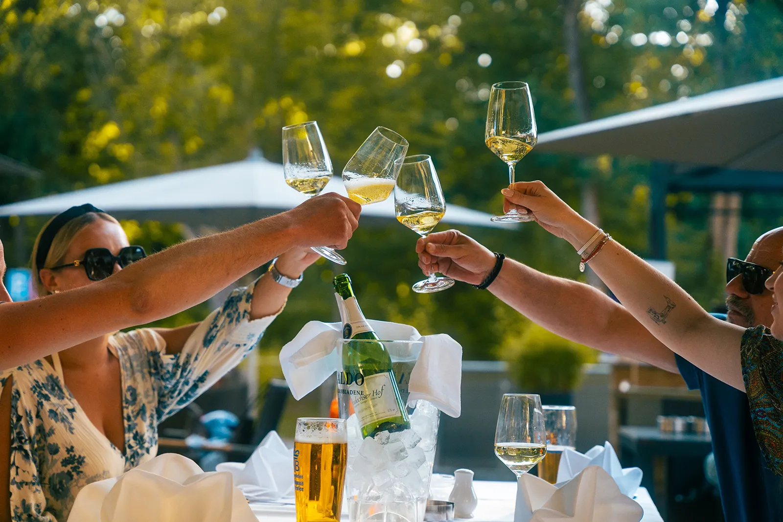 Gäste stoßen im Biergarten des Andechser Hofs an