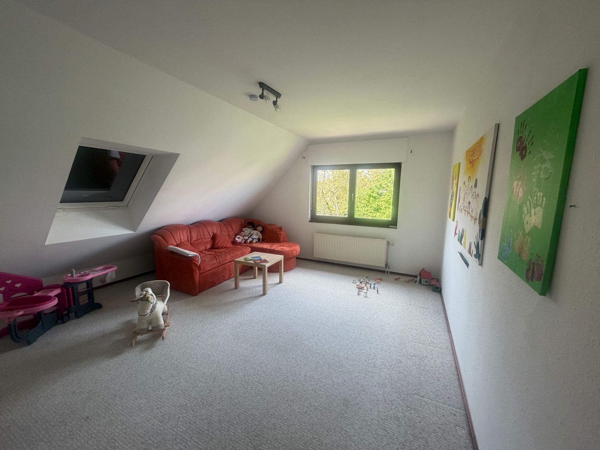 Spielzimmer mit rotem Sofa und Schaukelpferd