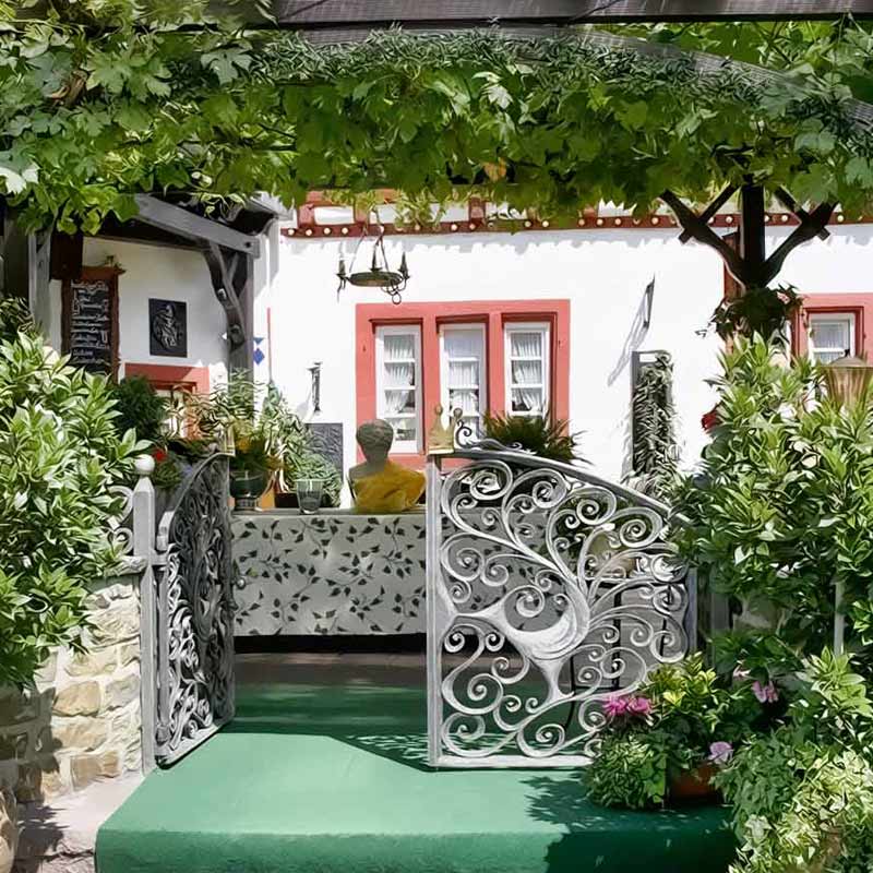 Terrasse des Hotel Rheingraf mit Weinreben und historischem Eingang